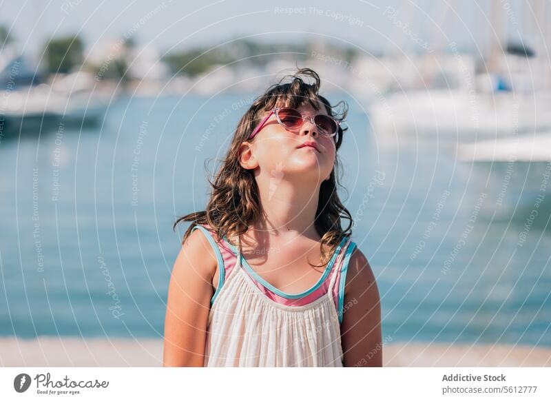 Mädchen mit Sonnenbrille an der Küste im Sommer niedlich Strand Porträt selbstbewusst Freizeitkleidung Kindheit stehen MEER verschwommener Hintergrund sonnig