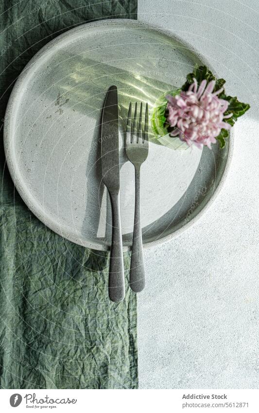Elegant gedeckter Tisch mit floralem Akzent Einstellung Teller Besteck Gabel Messer Blume Stoff Textil von oben nach unten Ansicht schick elegant frisch geblümt
