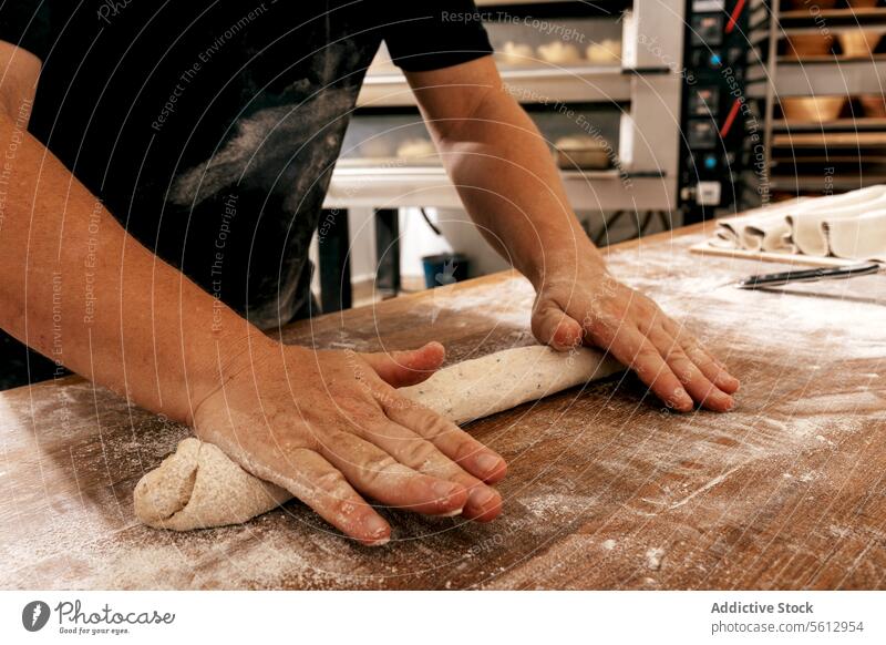 Hände eines Kochs kneten Brotteig in einer Bäckerei Teigwaren Kneten Tisch Mehl Küche Hand Ernte anonym Gebäck unkenntlich hölzern Körperteil handgefertigt roh