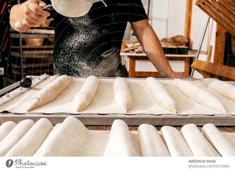 Erntehelfer siebt Mehl auf rohes Brot in einer Bäckerei Sieben Brotlaib Teigwaren Tablett Hand Facelift backen Freizeitkleidung Beteiligung Herstellung Küche
