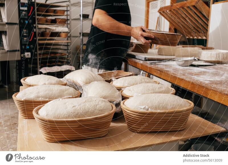 Mann bedeckt Brotteig in Behälter mit Plastik männlich Bäcker Sauerteig Schimmelpilze Kunststoff deckend Tisch Bäckerei Fokus professionell ungekocht roh