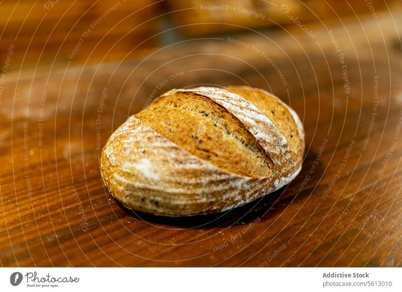Nahaufnahme eines frisch gebackenen leckeren Brotes mit knuspriger Kruste auf einem Holztisch in der Küche einer Bäckerei Brotlaib Knusprig Tisch hölzern