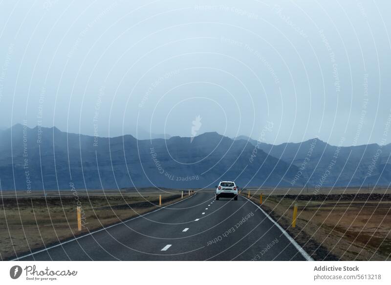 Rückansicht eines Autos, das auf der Straße durch das neblige Hochland von Island unter bewölktem Himmel fährt Highlands PKW reisen Abenteuer Einsamkeit Nebel