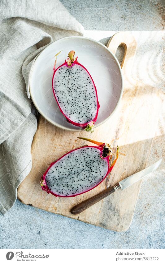 In Scheiben geschnittene Drachenfrucht auf rustikalem Küchenset aufgeschnitten Keramik Teller hölzern Schneidebrett altehrwürdig Messer tropische Früchte