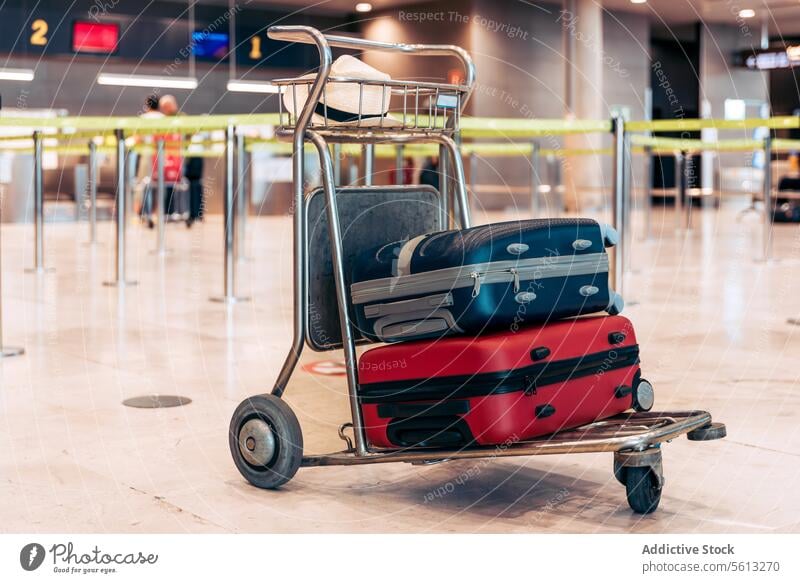 Trolley mit Koffer und Hut am Flughafen Handwagen Terminal farbenfroh Stahl modern Ausflug verschwommener Hintergrund Gepäck Urlaub Feiertag Abheben Ankunft