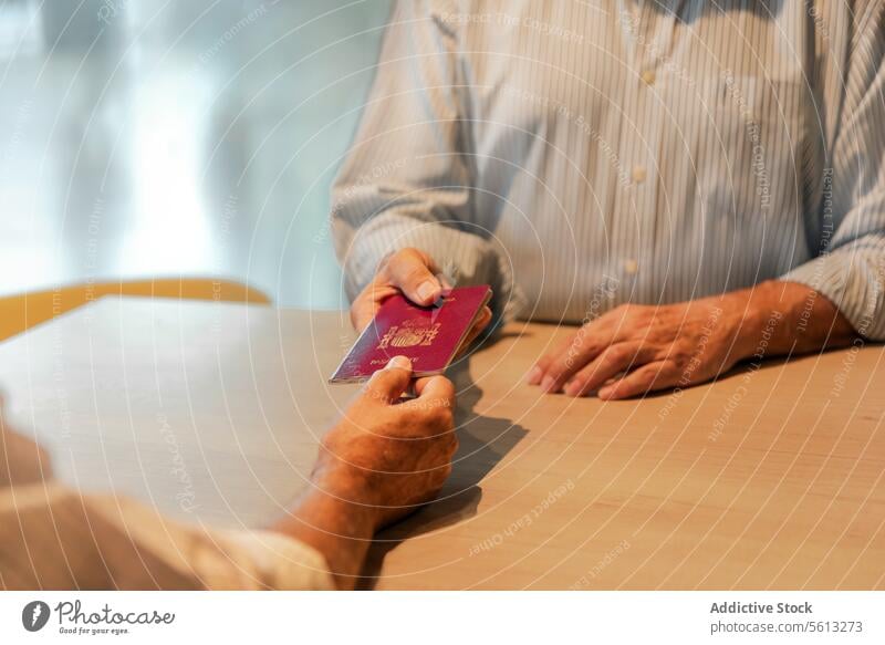Älterer Mann mit Reisepass beim Einchecken Senior Vermittler Hand Ernte weiß Hemd Empfang Check-in Flughafen Urlaub reisen unkenntlich gesichtslos Tourist