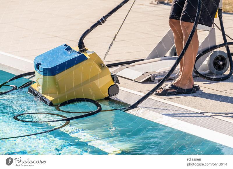 Poolreinigungsroboter, der von einer Person neben einem Schwimmbad platziert wird Frau Dienstleistungsbranche Technikeruniform Reinigungsroboter Poolpflege