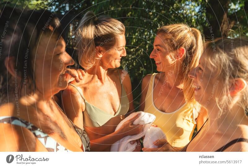 Gruppe von Frauen, die nach einem finnischen Saunagang in Handtücher eingewickelt sind und fröhlich plaudern finnische Sauna Erholung nach dem Saunagang