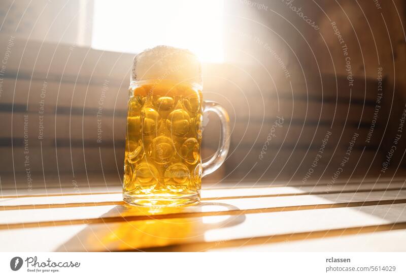 bierkrug mit schaumigem bier ruht auf einem ledge in einer finnischen sauna, fängt sonnenlicht. spa und wellness konzept bild Finnisch Spa Innenbereich