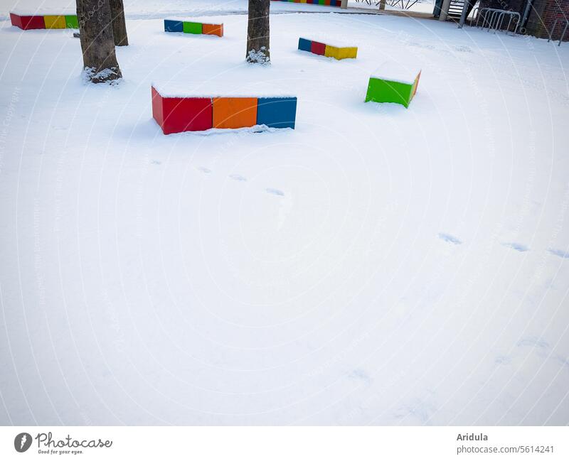 Bunte Betonklötze im Schnee Winter Bank Bäume Schulhof bunt Sitzgelegenheit Schule Pausenhof kalt Menschenleer Baum weiß Außenaufnahme Kind Kinder