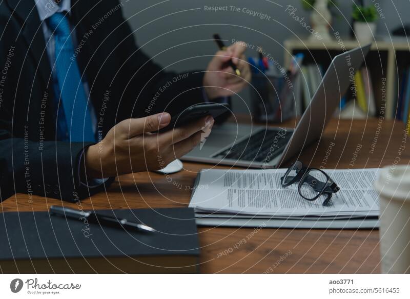 Geschäftsanalyse Marketing Finanz- und Dateneinblicke. Hand Mann hält mobile Smartphone auf dem Schreibtisch. Mobile Dokumente Telefon Schriftstück Handy