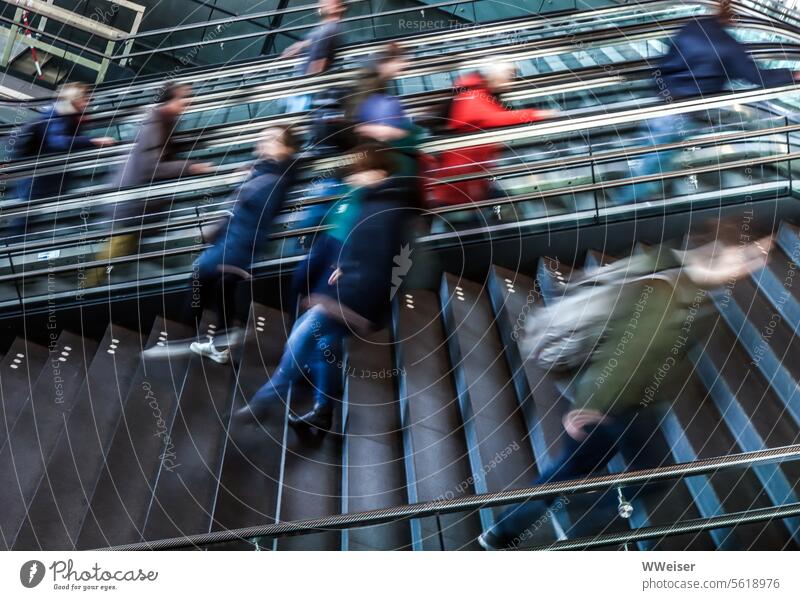 Treppen und Rolltreppen in einem Bahnhof, über die Menschen auf und ab eilen rush hour passagiere Stufen schnell Bewegung hoch runter Hektik Großstadt urban