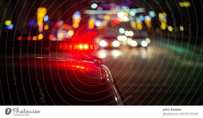 Polizeiauto Lichter in der Nacht Stadt mit selektiven Fokus und Bokeh abstrakt Unfall Alarm PKW Großstadt Szene Nachrichten Notfall Straße Verbrechen Dienst rot