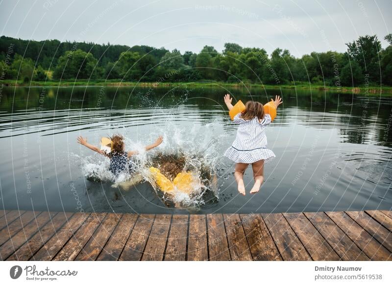 Kinder haben Spaß an einem See und springen ins Wasser Aktivität sorgenfrei Kindheit Schiffsdeck Kleid genießen Genuss Freiheit Freunde Freundschaft Mädchen