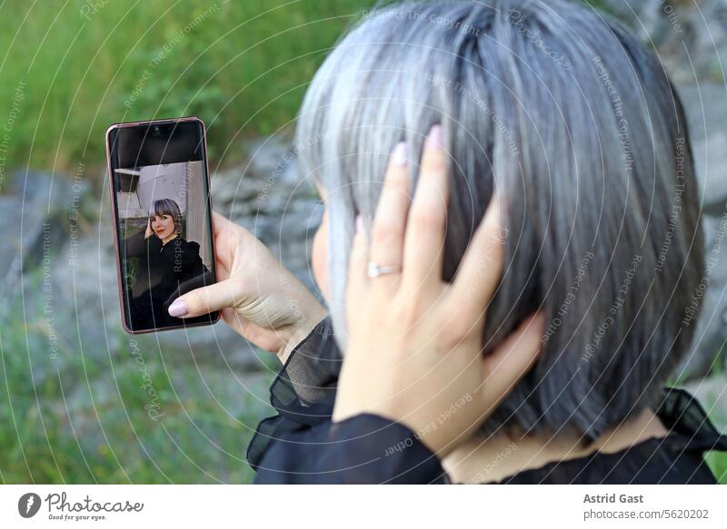 Eine Frau macht ein Selfie von sich frau selfie selbstportrait selbstporträt handy smartphone foto fotografieren eigenprotrait telefon spaß freude internet