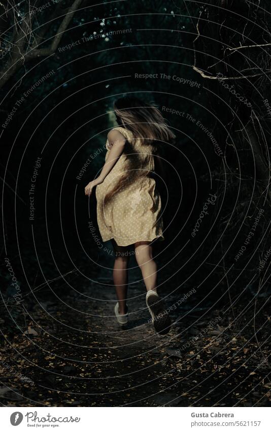 Eine Frau läuft durch den dunklen Wald. Deckung schwarz laufen Außenaufnahme Natur Farbfoto Spannung Thriller Krimi dunkel Kriminalroman Angst Einsamkeit