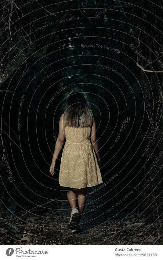 Frau geht auf einem dunklen Pfad im Wald. laufen Außenaufnahme Natur Farbfoto Spannung Thriller Krimi dunkel Kriminalroman Panik Angst Einsamkeit Schatten