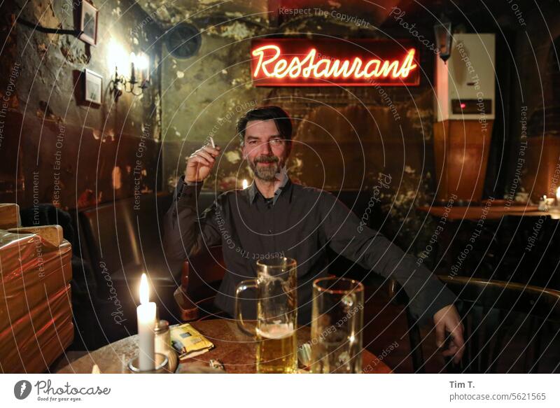 Mann mit Zigarette im Restaurant Berlin Farbfoto Rauchen Mensch Porträt Gesicht Nikotin Hand Tabakwaren ungesund Bier gesundheitsschädlich Gesundheitsrisiko