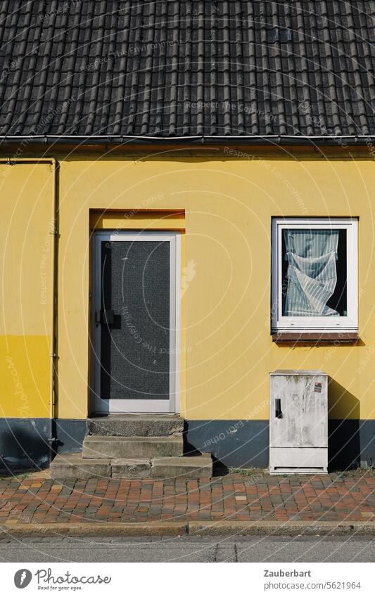 Gelbe Fassade, Haustür, Verteilerkasten, Bürgersteig, eine Gardine mit Faltenwurf und eine Stromleitung als Archetyp der Behausung gelb Leitung Fenster Eingang