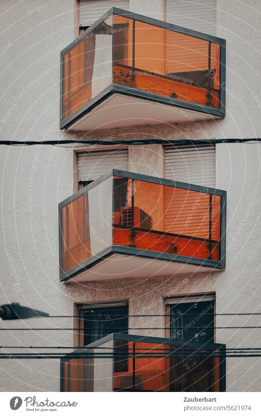 Dreieckige verglaste Balkone in orange an moderner Hausfassade dreieckig Struktur Architektur wohnen Wohnung Wohnwelt unwirtlich unwohnlich Fassade Gebäude