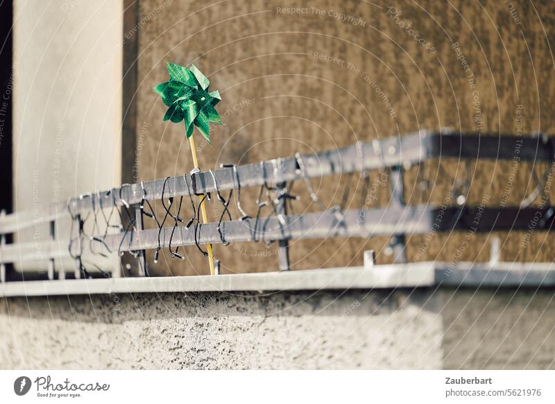Grünes kleines Spielzeug-Windrad auf Balkon, Lichterkette grün braun grau tapfer trostlos lustig einsam fröhlich allein niedlich spielen optimistisch