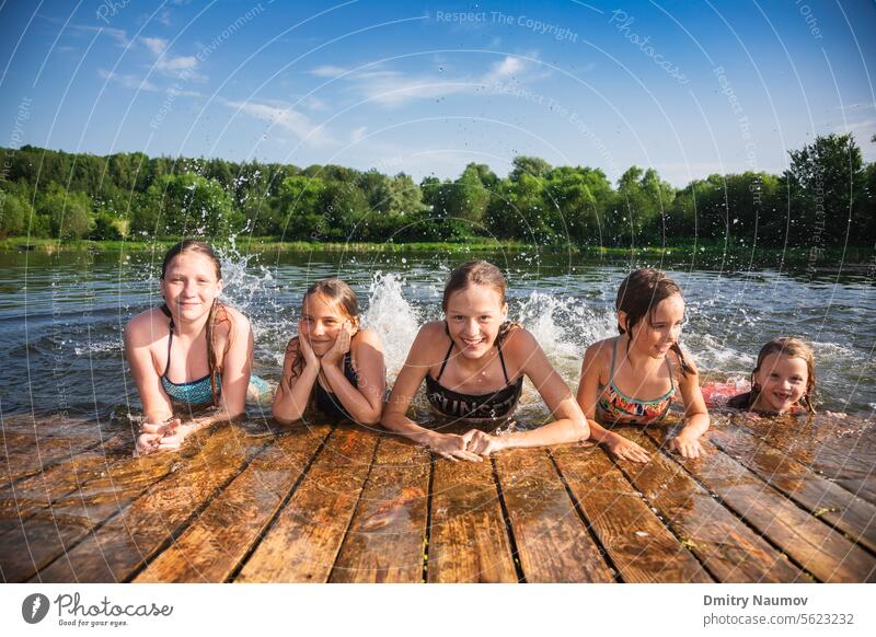 Glückliche kleine Mädchen, die in den Sommerferien in einem See spielen und Wasser spritzen Aktivität sorgenfrei Kind Kindheit Kinder Schiffsdeck Emotion