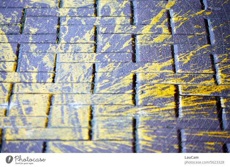 !Trash! 2023 | gelbe Farbe auf Asphalt Farbkleks Farbspritzer Straßenpflaster Pflastersteine Kopfsteinpflaster Fleck Unfall Missgeschick beschmiert Bürgersteig
