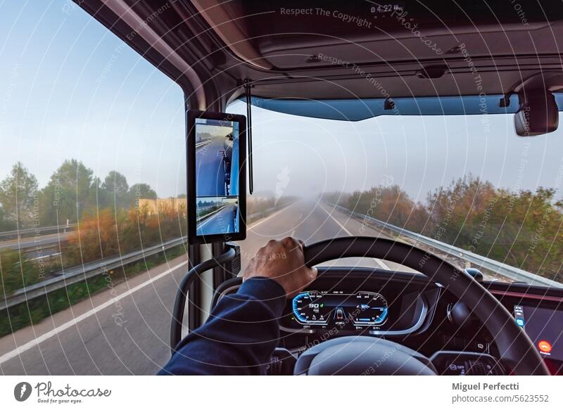 Blick aus dem Inneren der Kabine eines Lkw auf einer Autobahn mit Nebel, Lkw mit Rückfahrkamera und Bildschirm. Lastwagen im Inneren Armaturenbrett Rückansicht