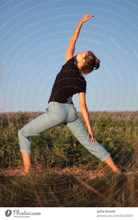 Yogaübungen im Freien yogaübung draußen Feld Sommer Wiese Acker Blumenfeld Sonnenlicht Frau sportlich Yogalehrerin Körperhaltung Körpergefühl Kraft und Stärke