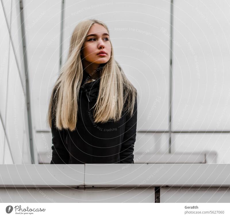junges Mädchen mit blonden Haaren und schwarzer Kleidung vor einem grauen Gebäude Erwachsener Architektur Herbst schön Schönheit schwarze Kleidung blondes Haar