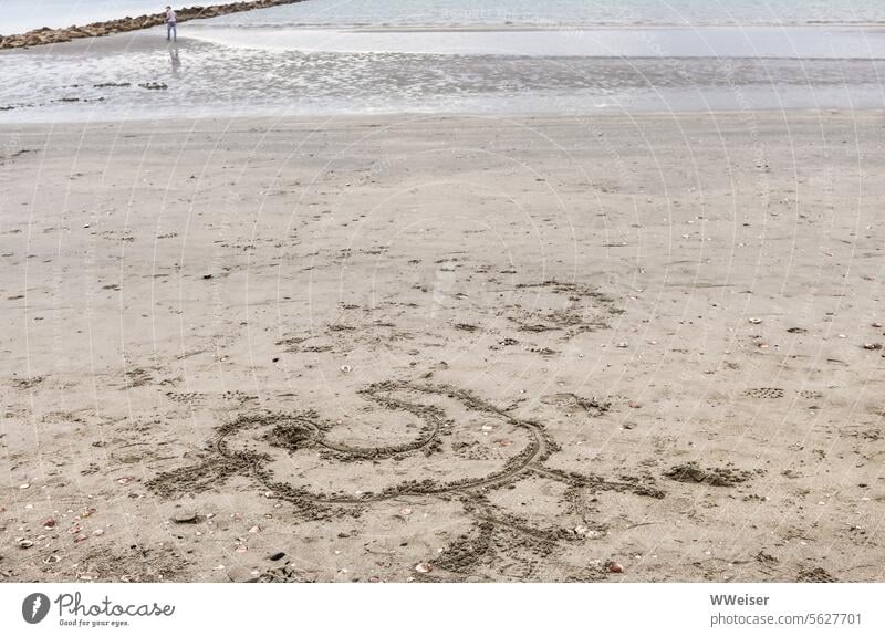 Ein leerer Strand bei bewölktem Wetter im Herbst mit einer in den Sand gezeichneten Ente Zeichnung Meer Adria Mittelmeer Italien Marina Ravenna See Sandburg