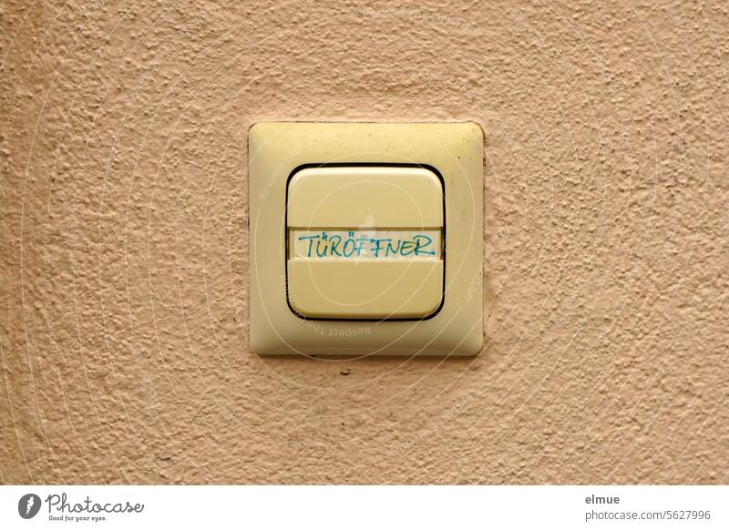 Tastschalter mit der Aufschrift TÜRÖFFNER an einer beigefarbenen Wand Schalter Türöffner Druckschalter Elektroinstallation Technik & Technologie Elektronik