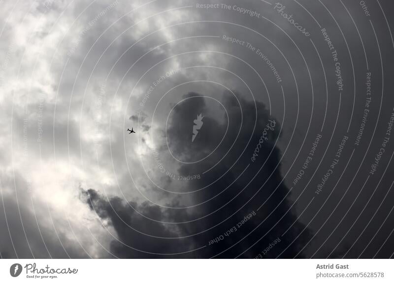 Ein Passagierflugzeug fliegt in eine Gewitterwolke gewitter wolken fliegen dunkel gefahr wolkig sturm passagierflugzeug risiko flugangst düster unheimlich