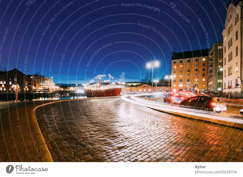Helsinki, Finnland. Blick auf Pohjoisranta Straße in Abend oder Nacht Beleuchtung. Bunte Nacht Sternenhimmel in dunkelblauen Farben. Sky Glowing Stars Hintergrund. Himmel Gradient