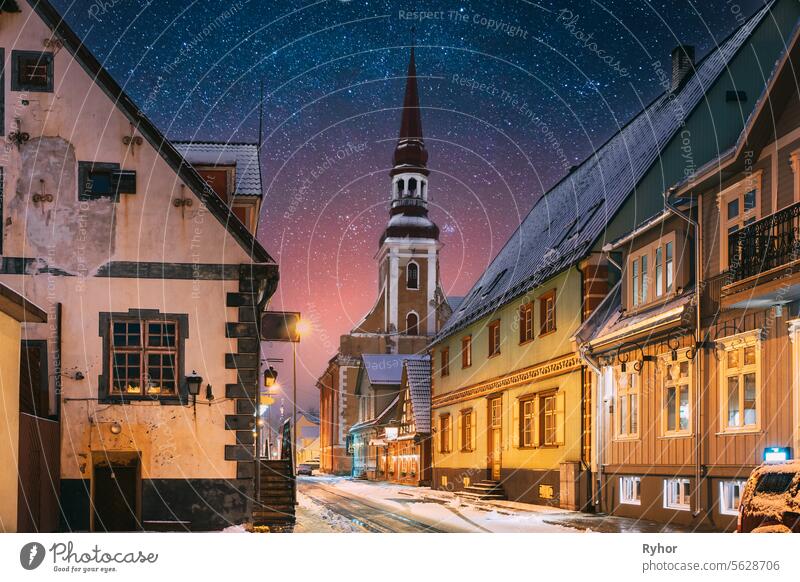 Parnu, Estland. Nachtansicht von Kuninga Straße mit alten Häusern in Abend Nacht Beleuchtungen. Amazing Bold Bright Blue Starry Sky Gradient. Ansicht der lutherischen Kirche St. Elisabeth auf Hintergrund
