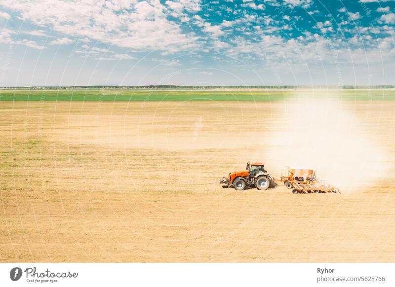 Erhöhte Ansicht Traktor mit Sämaschine Aussaat von Saatgut für Pflanzen im Frühjahr. Beginn der landwirtschaftlichen Frühjahrssaison. Countryside Rural Field Landschaft. Sonnenlicht Sonnenstrahl Sonnenschein