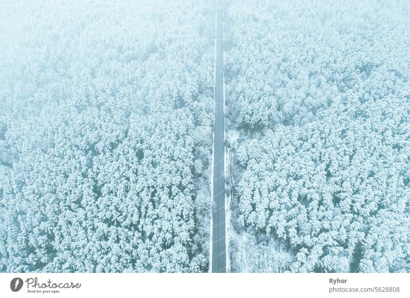 Luftaufnahme von Autobahn Straße durch Schnee Waldlandschaft im Winter. Top-Ansicht der Autobahn Autobahn aus hoher Haltung. Reise und Reisekonzept Szene Land