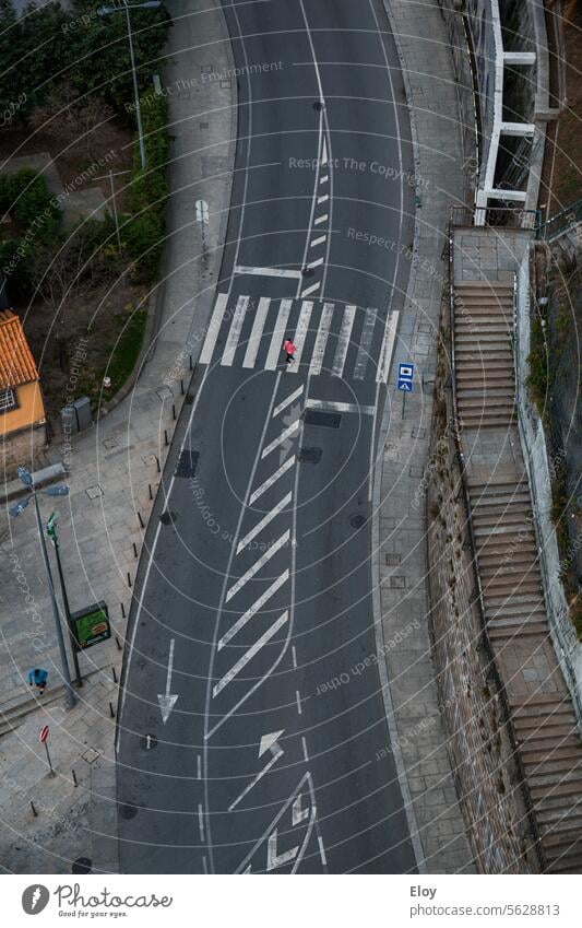 Straße, Luftaufnahme, ein Fußgänger überquert die Straße, auf der einen Seite sieht man eine lange Treppe und auf der anderen Seite einen Bürgersteig, man sieht nur eine Person und es gibt keine Autos
