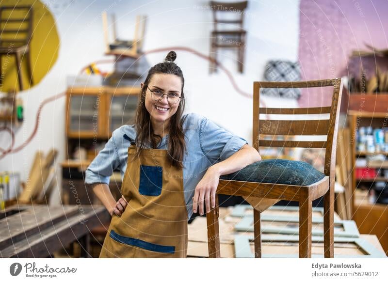 Porträt einer selbstbewussten Schreinerin in ihrer Werkstatt Möbel Zimmerer wiederherstellend Schreinerei Holz Stuhl Gebäude Herstellung Handwerk Renovierung