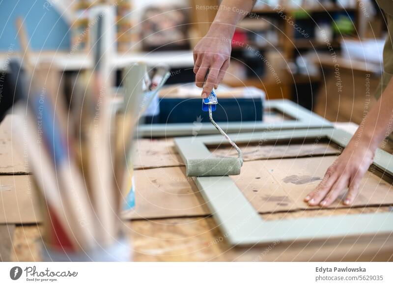 Schreinerin bemalt Möbel in ihrer Werkstatt Zimmerer wiederherstellend Schreinerei Holz Stuhl Gebäude Herstellung Handwerk Renovierung reparierend Handwerker