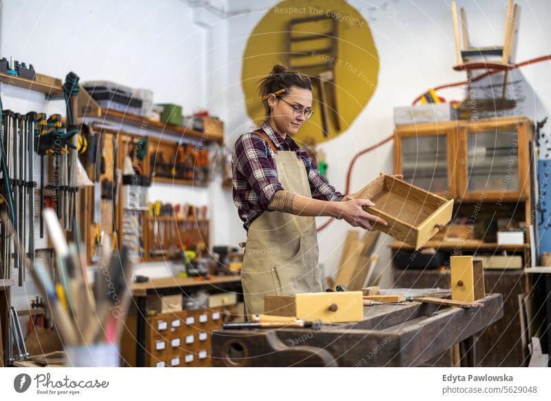 Porträt einer jungen Schreinerin bei der Arbeit in ihrer Werkstatt Möbel Zimmerer wiederherstellend Schreinerei Holz Stuhl Gebäude Herstellung Handwerk