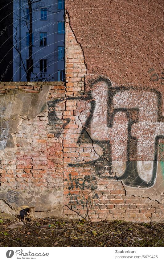 Brandmauer mit abgeplatztem Putz und Graffiti im warmen Licht Mauer Strukturen Formen street art Stadt wohnen Wohnhaus Mietskaserne Verfall Stimmung Wand