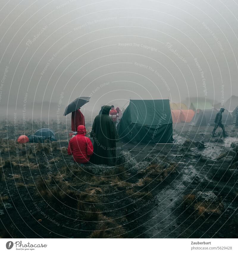 Wanderer und Träger, ein Regenschirm, Zelte, Nebel und Morast im Camp auf dem Kilimanjaro Lager wandern Aufstieg unheimlich ungemütlich Wolken Natur Abenteuer