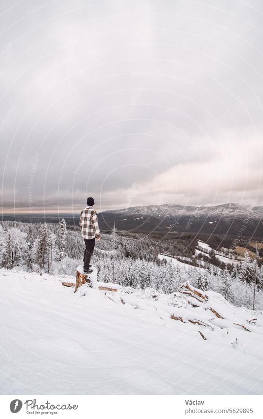 Wanderer schaut sich in der verschneiten Landschaft um. Winterwanderung durch unberührte Landschaft in den Beskiden, Tschechische Republik. Lebensstil beim Wandern