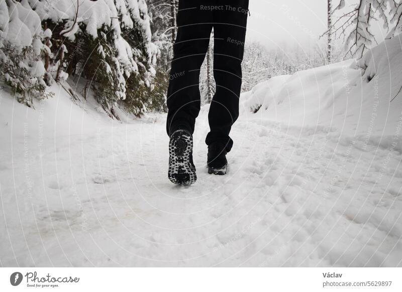 Aufnahme von Stiefeln, die vom Schnee in den Beskiden im östlichen Teil der Tschechischen Republik schlammig sind. Weißes Märchen in den Wintermonaten Fuß
