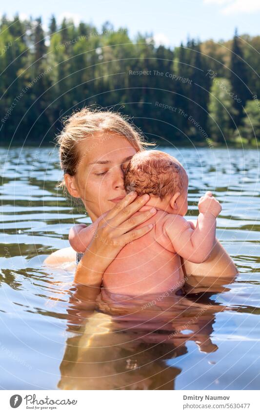 Mutter schwimmt mit ihrem kleinen Mädchen in einem Sommersee Gewöhnung junger Erwachsener Akklimatisierung im Freien alternativ Baby Bad baden Baden Camping