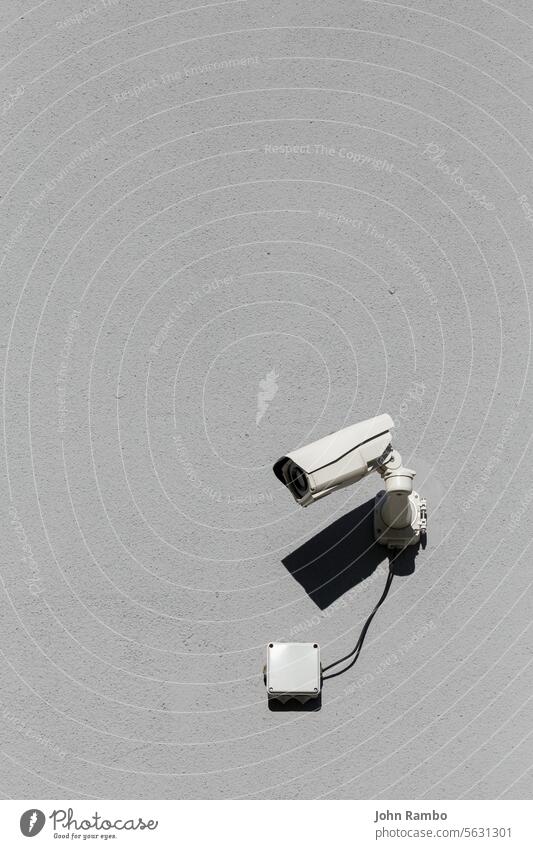 kleine weiße Überwachungskamera auf flacher grauer, matter Gipswand wertlos Überlebensfähigkeit Fotokamera Wand Gebäude Großstadt urban Kontrolle Kraft