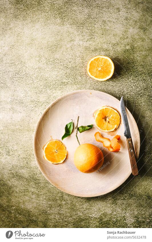 Orangen auf einem Teller. Grüner Tisch, Draufsicht. orange Obst Frucht saftig reif Scheibe grün Vitamin Diät tropisch Zitrusfrüchte frisch organisch gelb Blatt