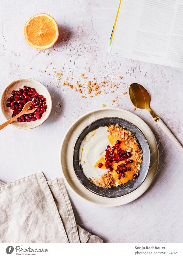 Eine Schüssel mit Müsli, Joghurt und Obst auf einem Tisch. Draufsicht. Frühstück Frucht Diät orange Granatapfel Haferflocken Schalen & Schüsseln Lebensmittel