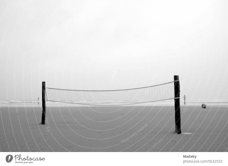 Volleyball Netz für Beach Volleyball bei Regen und Sturm am Strandspielplatz am Strand von St. Peter-Ording im Kreis Nordfriesland in Schleswig-Holstein im Herbst an der Nordseeküste in Schwarzweiß